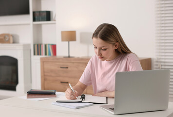 Poster - Online learning. Teenage girl writing in notepad near laptop at table