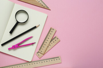 Wall Mural - Different rulers, pencil, compass and magnifying glass on pink background, flat lay. Space for text
