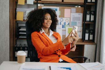 African business woman are delighted and happy with the work they do on their tablet, laptop and taking notes at the office.