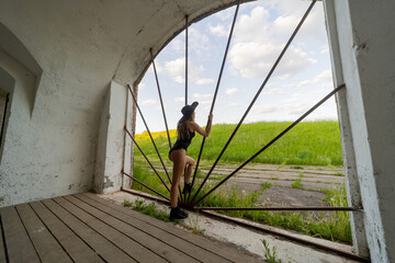 A girl with a good figure in a bikini is imprisoned behind iron bars