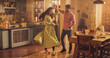 Young Couple Dancing and Having Fun in the Kitchen. Boyfriend and Girlfriend Sharing Moment of Love and Tenderness. With Joyful Laughter and Smiles, they Embrace the Music and Dance. 