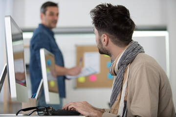 men in the office working on a laptop