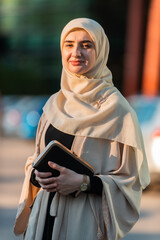 Wall Mural - Portrait of a Muslim business woman in the city street near the office building.