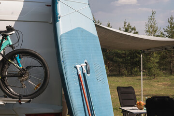 Inflatable Sup rowing boards stand near the motorhome inflated in nature during the day