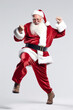 A man dressed as santa claus is jumping in the air. Generative AI. Santa Claus dancing, having fun.