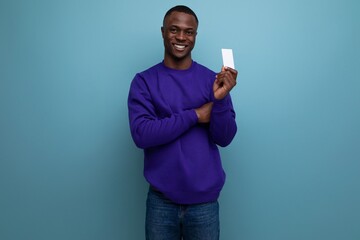 young african man in a blue sweater advertises a bank card