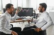 © Serhii - Two men traders sitting at desk at office together monitoring stocks data candle charts on screen analyzing price flow smiling cheerful having profit teamwork concept