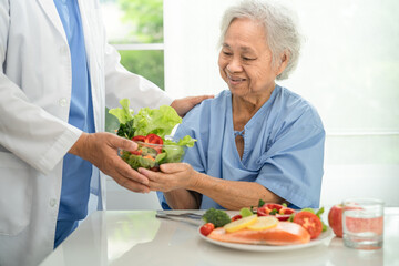 Wall Mural - Asian elderly woman patient eating salmon steak breakfast with vegetable healthy food in hospital.