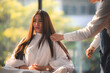 © chokniti - Asian Hairdresser giving treatment and barber occupation service, Professional hairstylist combing and using scissors cut woman's hair to young beautiful customer girl in beauty salon