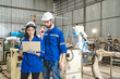 © chokniti - Testing new automation innovation tool for smart industrial, Professional robotic engineers specialist maintenance and control robot arm in factory warehouse, technician teamwork working together