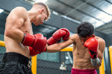 Two boxers Caucasian and Filipino boxers are fighting on professional boxing ring .It is a sport that trains endurance and physical strength.