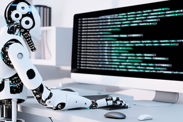 Android robot sitting at desk writing computer code.