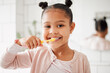 © K.A./peopleimages.com - Child, toothbrush and brushing teeth in a home bathroom for dental health and wellness with smile. Face portrait of african girl kid cleaning mouth with a brush for morning routine and oral self care