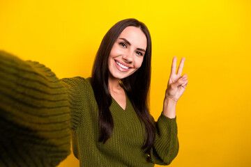 Sticker - Photo of cheerful nice girl beaming smile make selfie demonstrate v-sign isolated on yellow color background