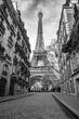 View of the Eiffel Tower from a nearby street full of residential buildings. Paris, France. Black and white photography.