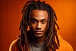 Jamaican man with dreadlocks in his hair posing in studio. Fictitious person generated by Ai.