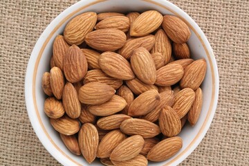 Wall Mural - Almond on eco canvas napkin background. Healthy eating diet, nutrition, vegan concept. Protein organic food. Dry snack. National nut day. Copy space for text