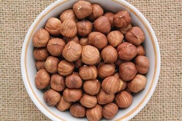 Wall Mural - Hazelnut on eco canvas napkin background. Healthy eating diet, nutrition, vegan concept. Protein organic food. Dry snack. National nut day. Copy space for text