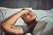 © Clement C/peopleimages.com - Tired, rest and sick man sleeping in the bedroom while in recovery or healing in his apartment. Burnout, illness and male person with a headache or fever taking a nap in bed at his modern home.
