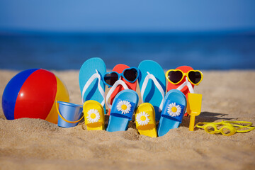 Family flip-flops, beach ball and snorkel on the sand. Summer vacation concept