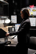 © DC Studio - Asian detective unpacking laptop before starting criminal investigation case. Private investigator woman in archive room office filled with criminology folder files on bookshelves