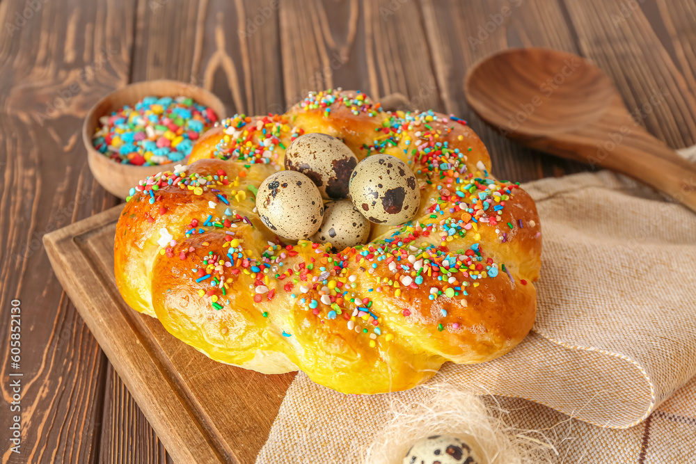 Board with tasty Italian Easter bread and eggs on wooden table, closeup