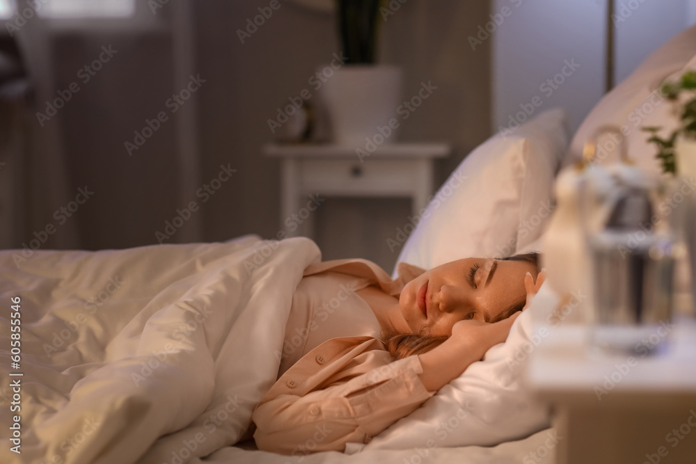 Young woman sleeping in bed at night