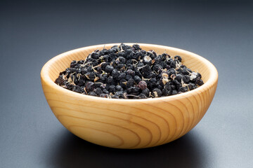 black Chinese wolfberry in a wooden bowl