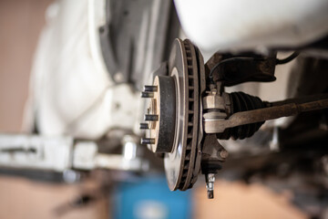 Poster - Disc brake of the vehicle for repair, in process of new tire replacement. Car brake repairing in garage.Suspension of car for maintenance brakes and shock absorber systems. Replacement of brake pads.