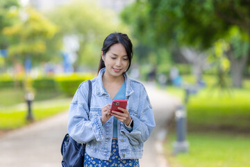 Poster - Woman use of mobile phone in the park