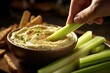 Close up shot of hand dipping celery into fresh hummus, Generative AI