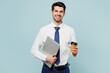 © ViDi Studio - Young employee IT business man corporate lawyer wear classic formal shirt tie work in office hold closed laptop pc computer drink coffee isolated on plain pastel light blue background studio portrait
