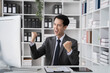 © NINENII - asian businessman are excited business success with inspiration from their excellent financial results that are happy working in a modern office on a computer.