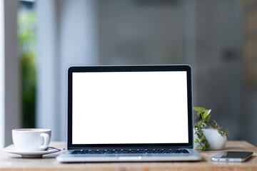 Wall Mural - Mockup of laptop computer with empty screen with coffee cup and smartphone on table of the coffee shop background,White screen