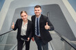 © เลิศลักษณ์ ทิพชัย - A business man and two business women smiling happily and confidently while walking on an escalator. business discussion work together to work at the office