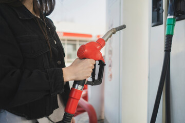 person holding a fuel pump on the gas station