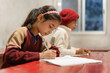 Indian children studying and taking notes in the classroom at school, learning and education concept.