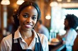 © Pictures Paradise - Portrait of smiling african american waitress in elegant restaurant looking at camera with bokeh background.