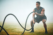 © Kirsten D/peopleimages.com - Fitness, battle rope and man on field for power workout for body building, training and muscle strength. Exercise, sports and bodybuilder on grass with ropes, energy and outdoor performance challenge