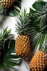  Fresh pineapple with tropical leaves on white background.