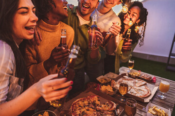 group multiracial friends at night terrace party with alcohol, happy group of young friends celebrating together