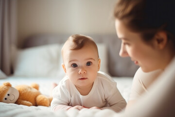 young mother playing with her sweet three month old baby in the bedroom