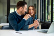 © bnenin - A business couple in love sitting in front of a laptop and using a credit card for online shopping.