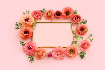 top view of pink flowers and gold elegant empty frame over pastel background. For mock up, copy space