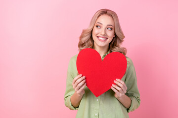 Sticker - Photo of positive cute girl toothy smile hands hold red paper heart look empty space isolated on pink color background