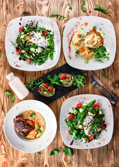 Wall Mural - Green salads with vegetables, eggs and greens with fried chicken legs with sauce and zucchini pancakes.