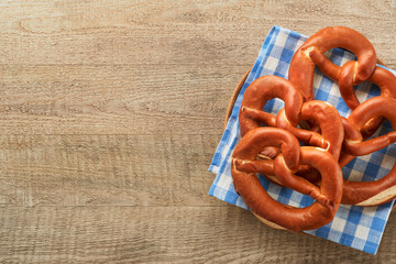 Wall Mural - Oktoberfest concept card. Traditional Bavarian pretzels with beer bottle mug on old rustic wooden background. Perfect for Octoberfest. Oktoberfest food menu. Top view. Mock up.