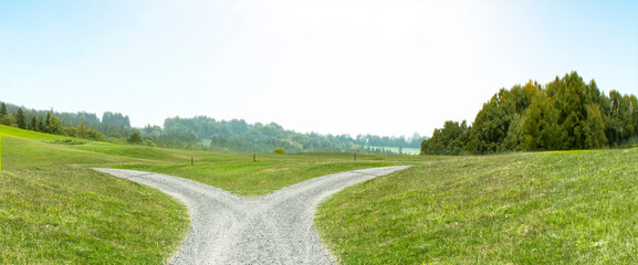 Weggabelung auf einem Weg durch durch eine Hügellandschaft