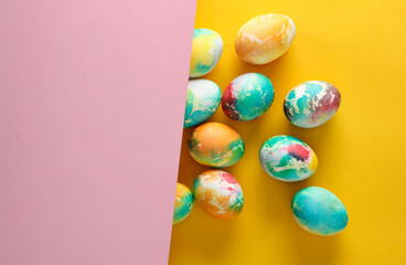 Wall Mural - Multicolored Easter eggs on yellow pink background. Copy space