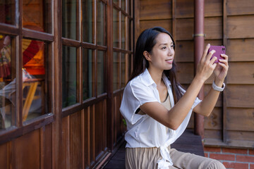 Sticker - Woman use mobile phone to take photo at Japanese wooden house